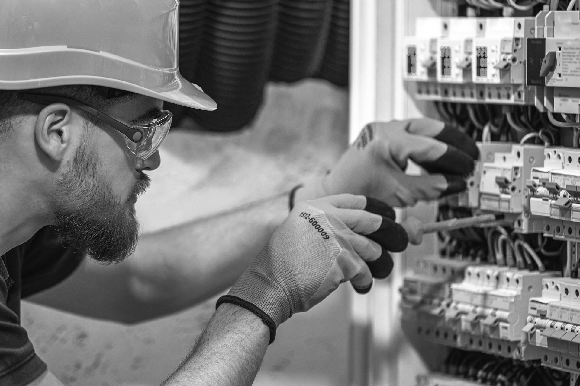 Male electrician working in a switchboard with fuses.